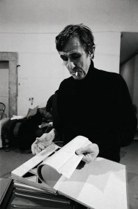 Alighiero Boetti in studio con uno dei 15 libri rossi, 1993 - foto Sandro Vannini